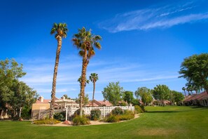 A residential area with palm trees, a white fence, and houses with red roofs. - ***Fully remodeled from top to bottom ***It's time to get Away!!! (Palm Desert)