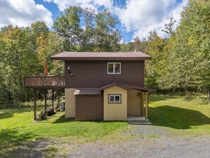 A two-story house with a deck, a small attached garage, and a front porch. - Modern Alpine Chalet 2 Miles from Belleayre (Pine Hill)