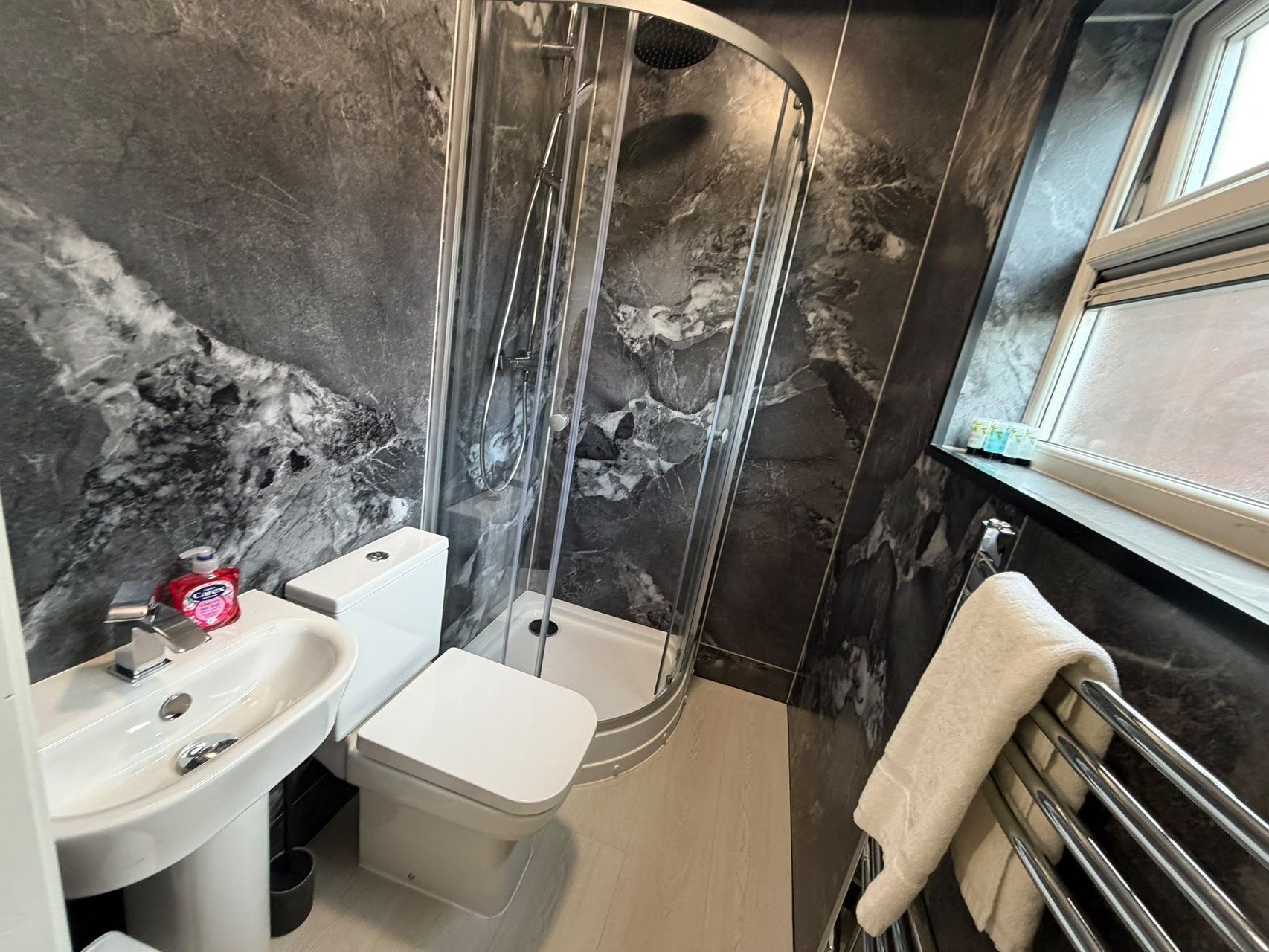 Ein Badezimmer mit Dusche, Toilette und Waschbecken.