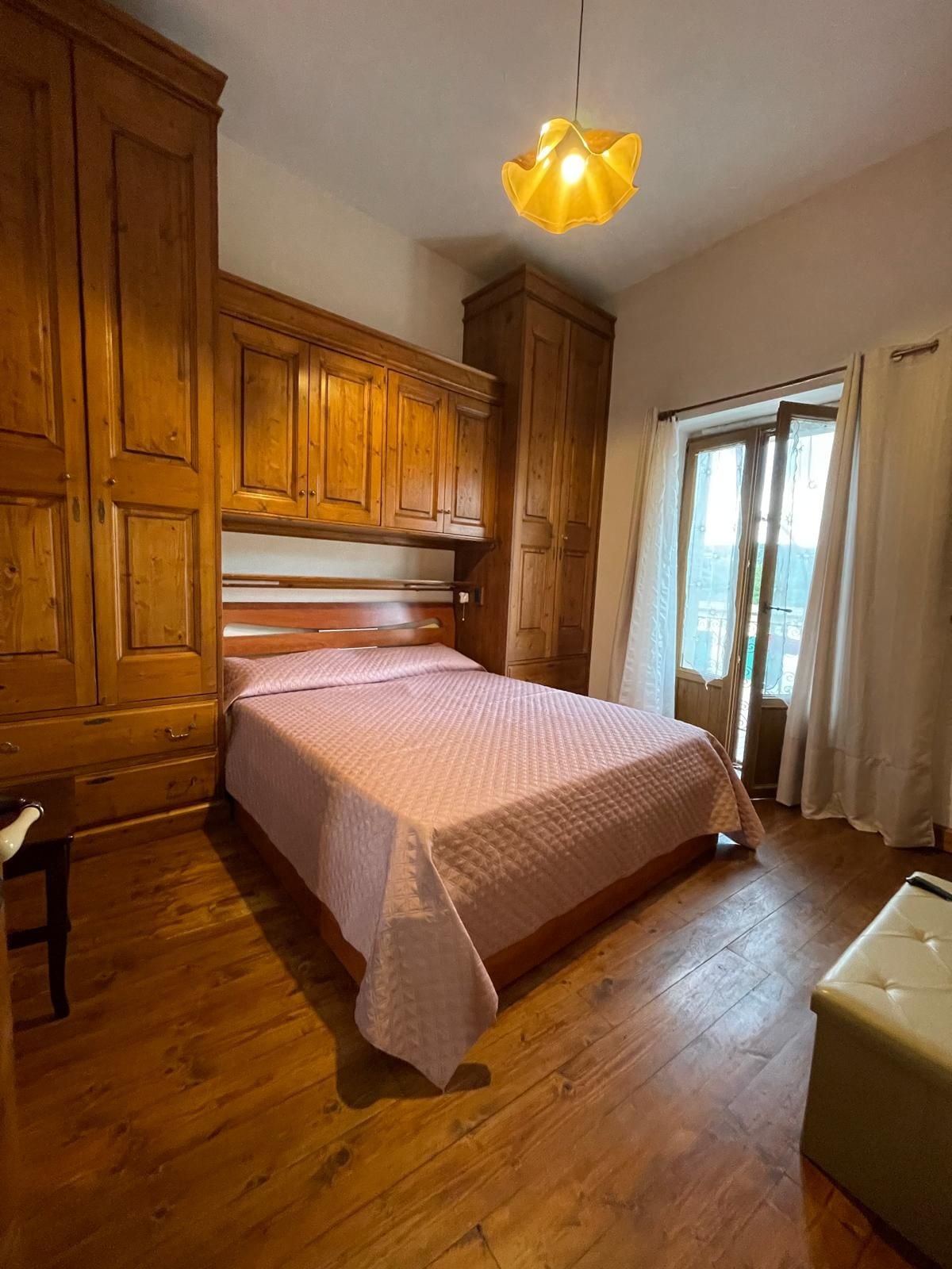 Una camera da letto con un letto in legno, un comodino e un'armadio.
