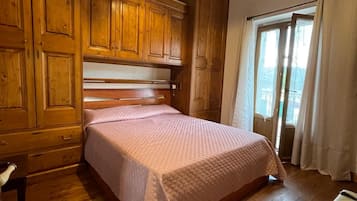 Una camera da letto con un letto in legno, un comodino e un'armadio.