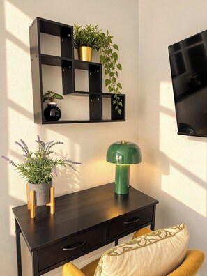 A modern room with a black desk, a green lamp, and a wall-mounted TV. - Cool Soho Room Steps from Chinatown & West End (Greater London)