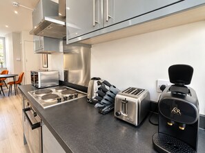 A modern kitchen with stainless steel appliances, a coffee maker, and a toaster. - Boutique-Style Room in London’s West End IV (Greater London)