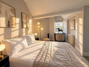 A bedroom with a large bed, bedside tables, a chair, and artwork on the walls. - Cosy Soho Room near Piccadilly & Chinatown (Greater London)