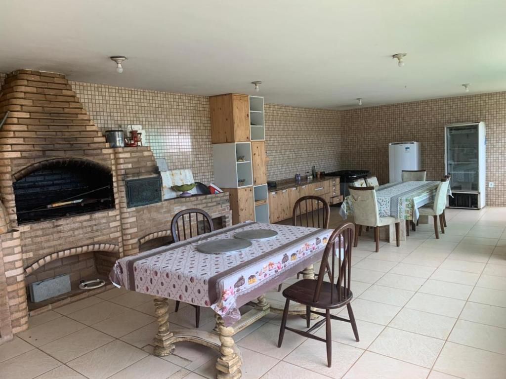 Une cuisine équipée d’un four à briques, d’une table à manger avec des chaises et d’un réfrigérateur.