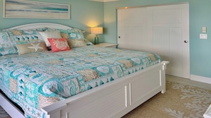 A bedroom with a bed, a nightstand, a lamp, a door, and a wall-mounted light switch. - Wake up to Clam Bay from this light- filled 2 bed 2 bath condo in South Seas Club on Marco Island (Marco Island)