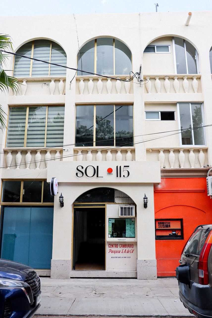 A building with a sign reading 'SOL 115' and a storefront labeled 'CENTRO CAMBIARIO Pacquic A & De GV.'