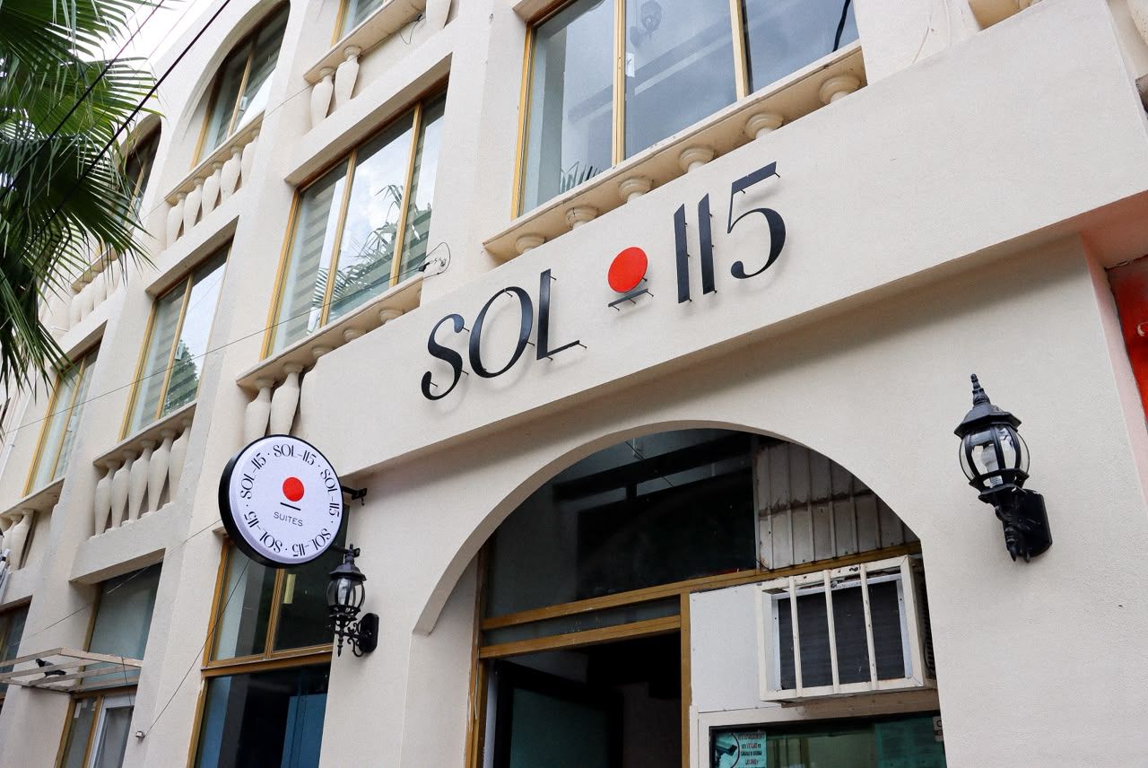 A building with the sign 'SOL 115' indicating a hotel or accommodation.