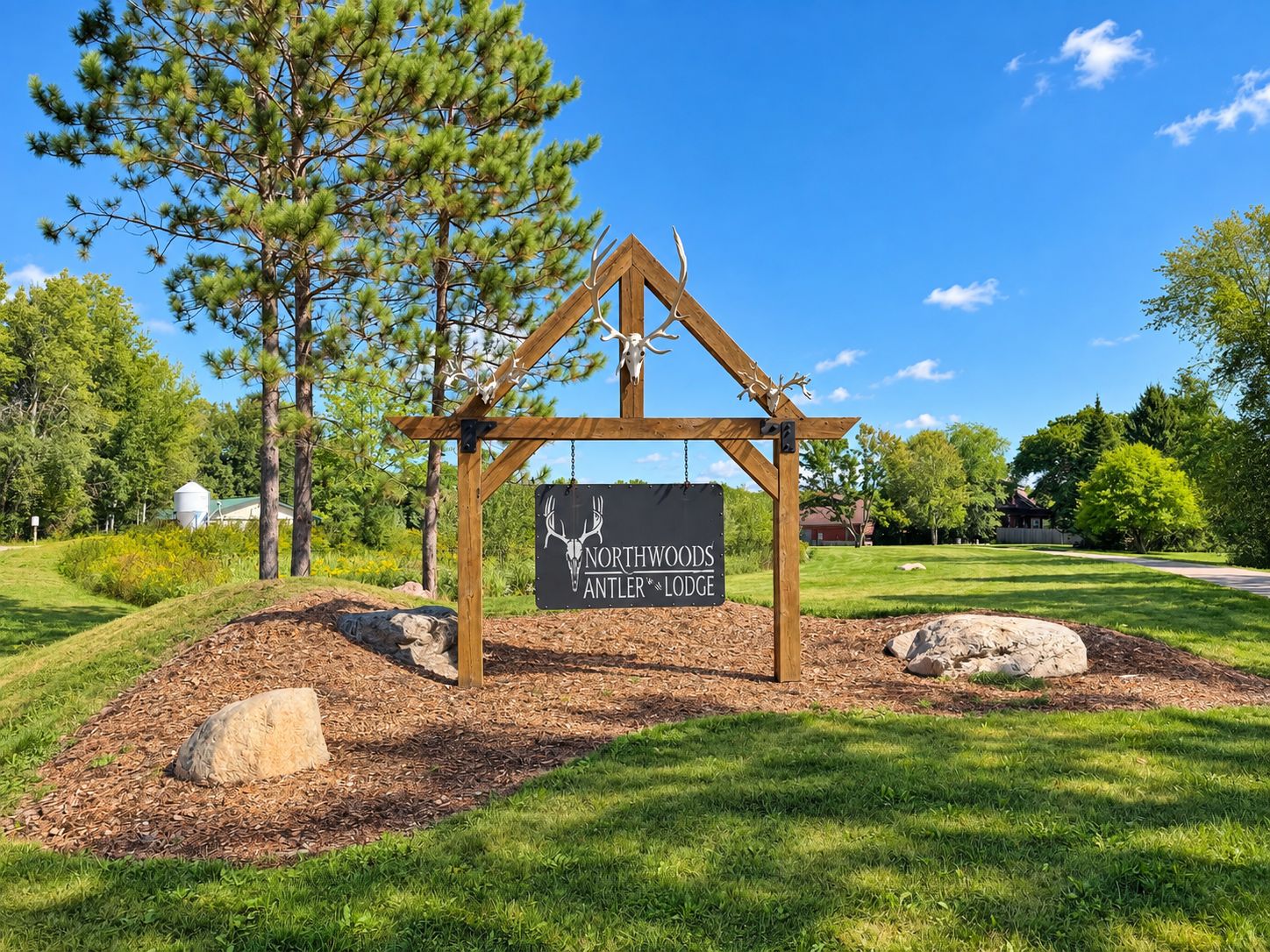 A wooden sign with a deer head logo and the text 'Northwoods Antler Lodge' mounted on a simple wooden structure.