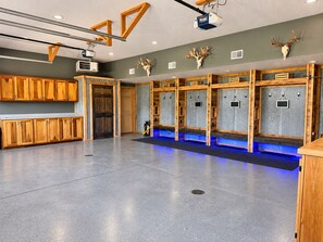 A locker room with wooden lockers, a projector, and deer antlers on the wall.