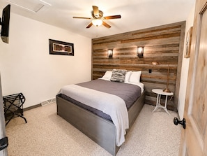Cozy private Queen bed bedroom with rustic wood accents, comfortable furnishings, and a peaceful atmosphere for resting after a day of ATV riding, snowmobiling, hiking, or exploring Birchwood. - State ATV Trail|Updated|Wildlife|Trailer Parking (Birchwood)