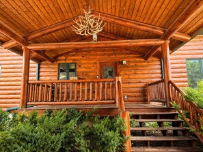 The covered entry porch adds a cozy cabin feel and creates a welcoming transition into the House. - Two Homes · Private Pond & ATV Trails · Sleeps 24 (Birchwood)