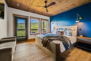 A bedroom with a bed, a nightstand, a chair, and a view of a balcony. - New! Loaded Luxury*Swim Spa*Theater*Games*Views! (Sevierville)