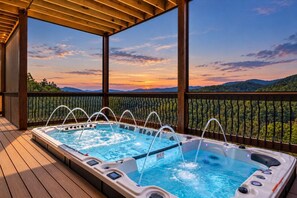 A hot tub with a wooden deck and a view of a mountainous landscape. - New! Loaded Luxury*Swim Spa*Theater*Games*Views! (Sevierville)