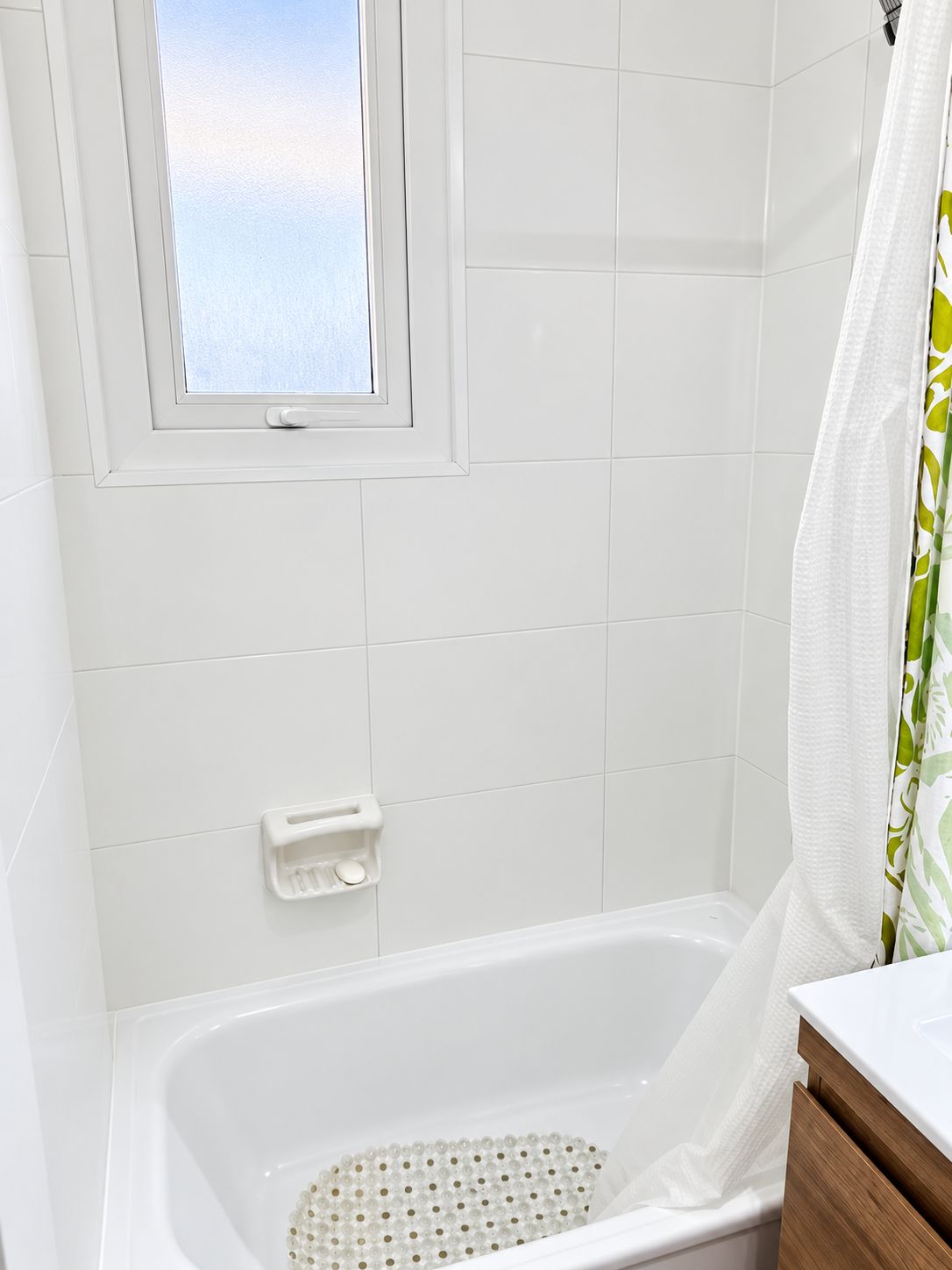 A bathroom with a bathtub, a window, and a shower curtain.