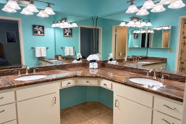 A bathroom with two sinks, a large mirror, and multiple light fixtures. - Isla Bella - Waterfront Retreat, Dock, Boat Lift (Port Isabel)