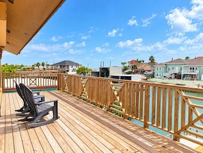 A wooden deck with a pool, overlooking a residential area with houses and a clear sky. - Isla Bella - Waterfront Retreat, Dock, Boat Lift (Port Isabel)