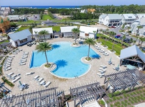 A resort with a large swimming pool surrounded by sun loungers and palm trees. - The Good Life (Santa Rosa Beach)