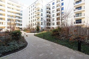 A modern apartment complex with a central courtyard, outdoor seating, and a well-maintained garden area. - Nowoczesne Studio - Modena (Poznań)