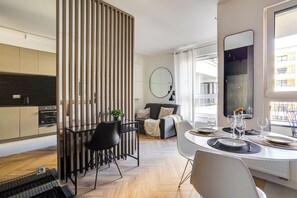 Una cucina moderna con zona pranzo, divano e un grande specchio.