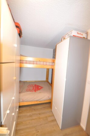 A small, enclosed room with a bunk bed, a wardrobe, and a refrigerator. - 350m from ski slopes, 1st floor, balcony, tv, ski locker, 26m², Valloire (Valloire)