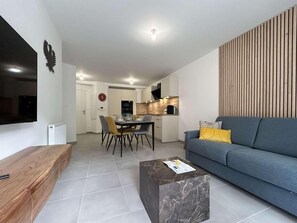 A modern living room with a sofa, a coffee table, and a dining area with chairs and a table. - 300m from ski slopes, 2nd floor, terrace, tv, ski locker, 58m², Serre Chevalier (Briançon)
