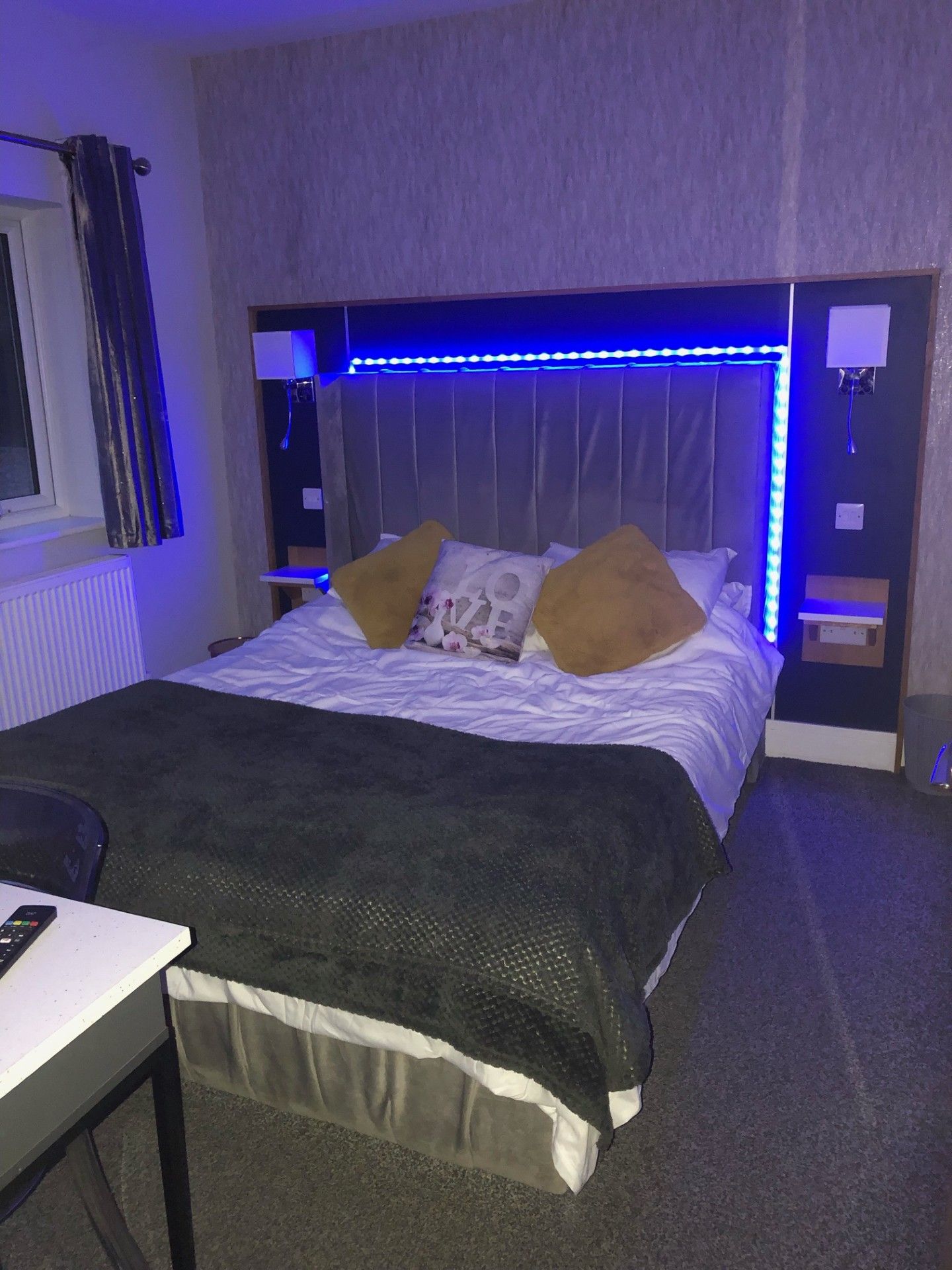 A hotel room with a bed, a desk, and a chair.