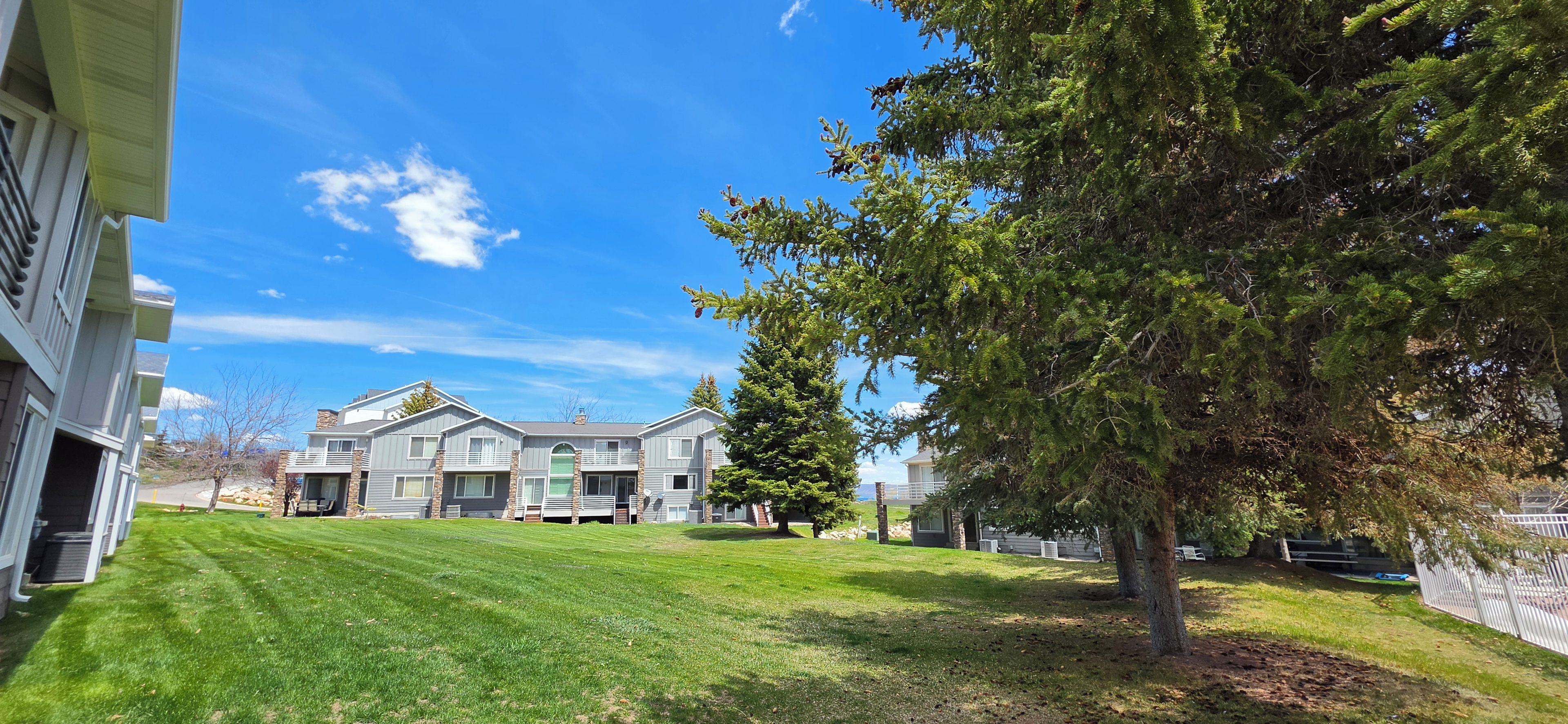 Spacious green lawn with mature trees and relaxing balcony views