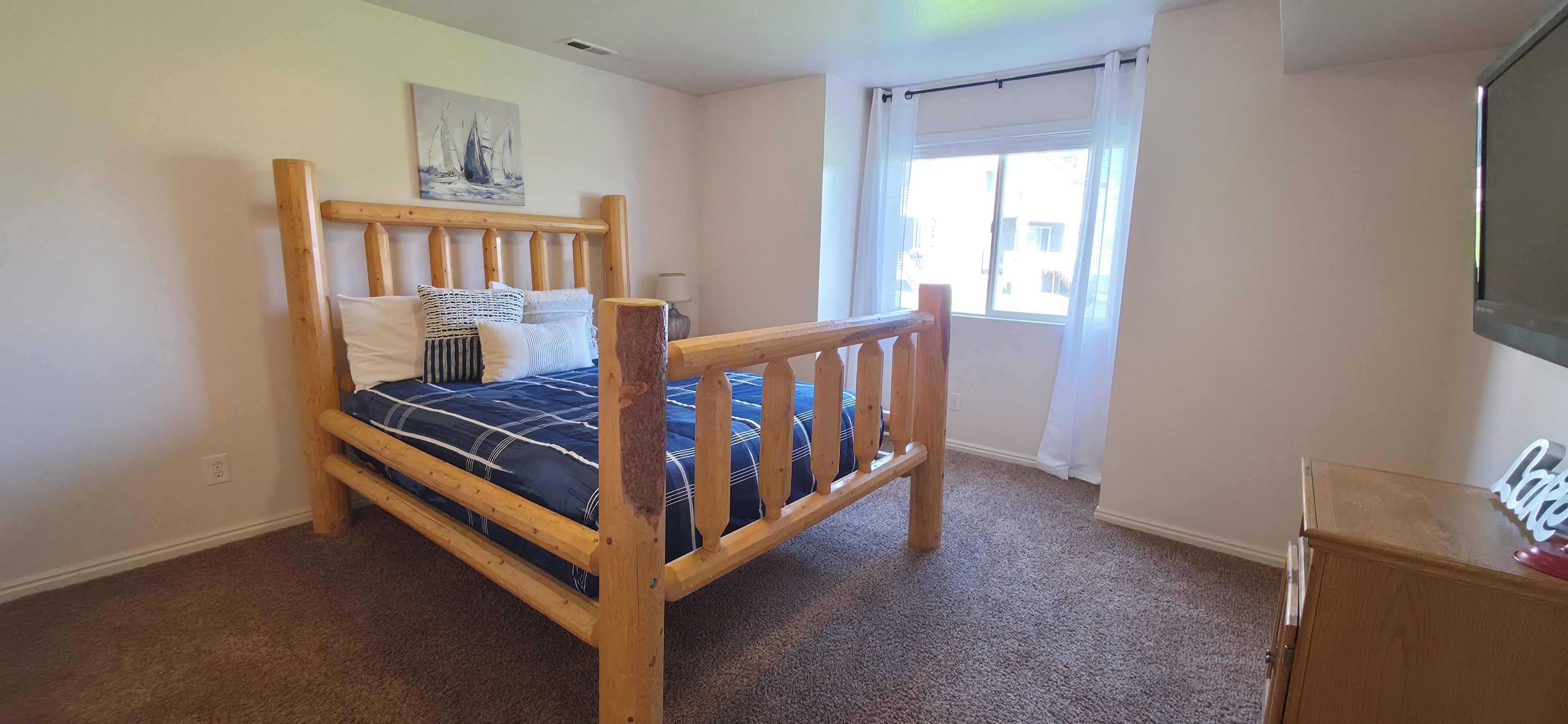 Bright bedroom with rustic log bed and plenty of natural light