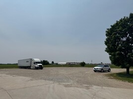 Un estacionamiento con una camioneta y un SUV blancos.