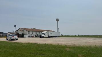 A building with a large water tower, a white truck, and a car parked in front.