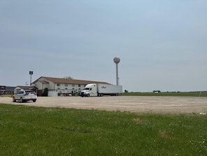 A building with a large water tower, a white truck, and a car parked in front.