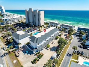 A coastal hotel with multiple buildings, a parking lot, and a view of the ocean. - Emerald Hill 21 (Santa Rosa Beach)