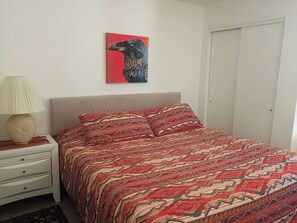 A bedroom with a bed, a nightstand, a lamp, and a wall-mounted painting. - Peaceful Laughlin Oasis - First Floor- No Stairs (Laughlin)