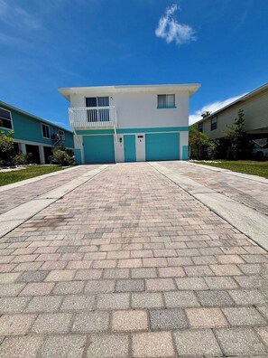 Un bâtiment doté d’un toit plat, d’un balcon et d’une porte de garage.
