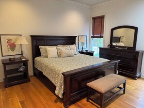 A bedroom with a large bed, bedside tables, a bench, a dresser, and a mirror. - Aspen Bend, a five bedroom retreat close to campus and town. (Oxford)