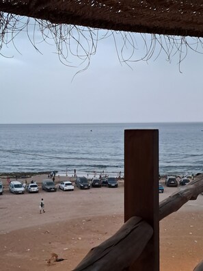 Ein Strand mit geparkten Autos und einer Holzkonstruktion.
