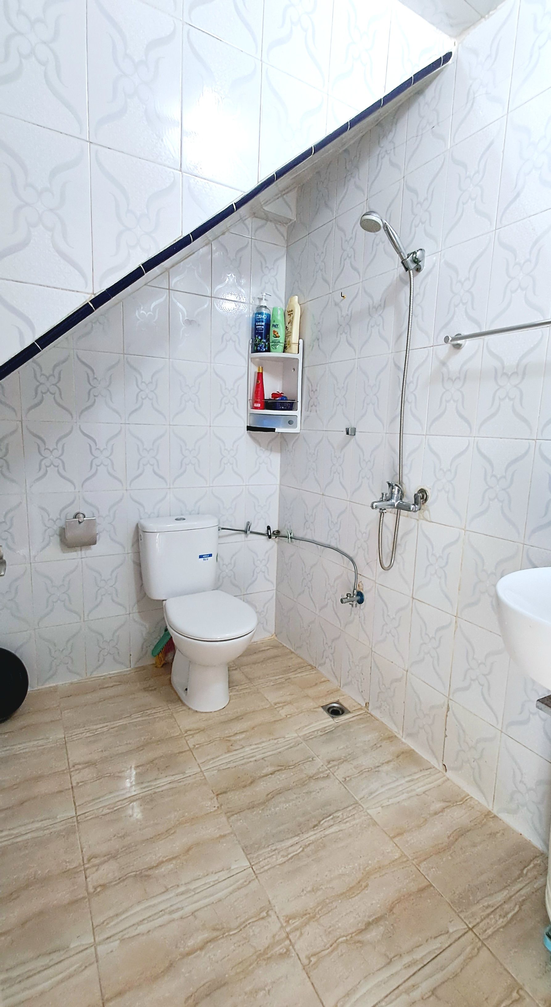 A bathroom with a toilet, shower, and sink.