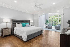 Primary suite with a king bed, hardwood floors and a sunny sitting area. - 6BR w/ 12 Beds - Golf Sim, Poker Room & Putting Green in Pinehurst (Pinehurst)