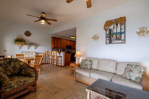 A living room with a sofa, a coffee table, and a dining area with chairs and a table. - LOWER Oceanfront Pool/kayak/paddleboard, caretaker (San Pedro)