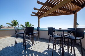 An outdoor patio with a pergola, tiled flooring, and wicker furniture. - UPPER 2BR/2BA Oceanfront w/Pool/kayak/paddleboards (San Pedro)