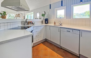 A modern kitchen with white cabinetry, a built-in dishwasher, and a window providing natural light. - Beautiful home in Hjørring with sauna (Hjørring)