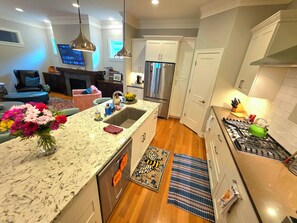 A modern kitchen with a built-in dishwasher, stainless steel appliances, and a large island with a sink. - Aspen Place | Zero-Step, 2 En-Suites, 1.5mi Mayo (Rochester)