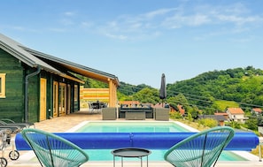 A pool with lounge chairs, a dining area, and a view of a hillside. - Beautiful home in Klokovec with sauna (Klokovec)