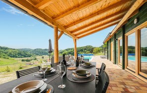 An outdoor dining area with a table set for a meal, overlooking a swimming pool and a scenic landscape. - Beautiful home in Klokovec with sauna (Klokovec)