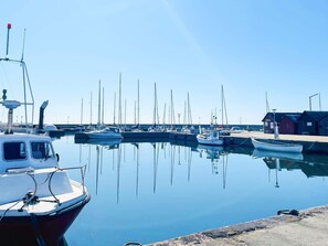 A marina with boats docked, a pier, and a small building. - 8 Person Holiday Home in Abbekas (Abbekas)