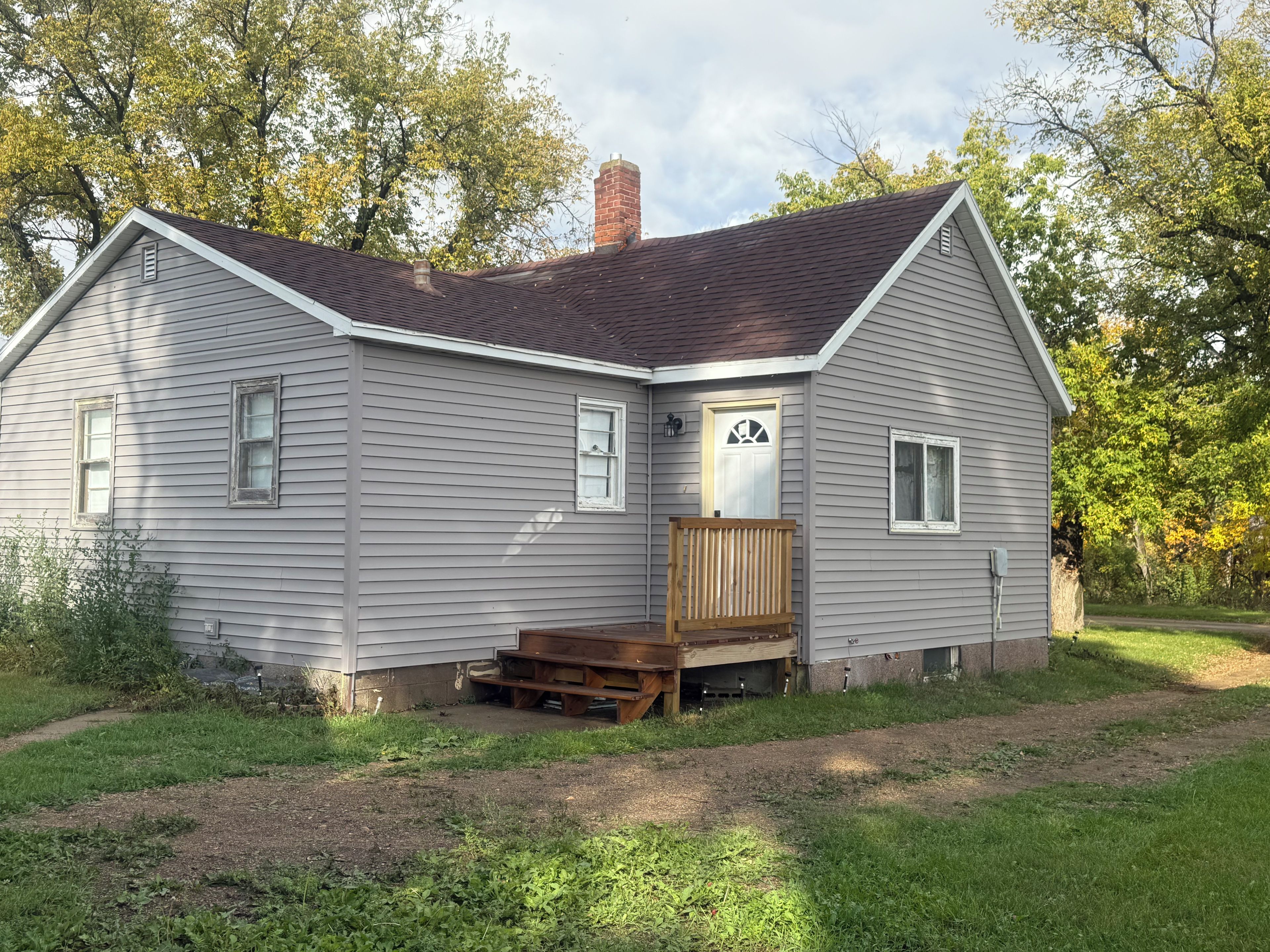 A single-story house with a front porch and a chimney.