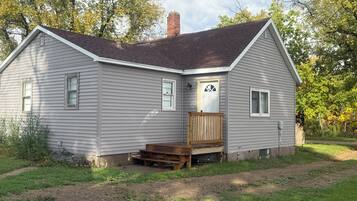 A single-story house with a front porch and a chimney.