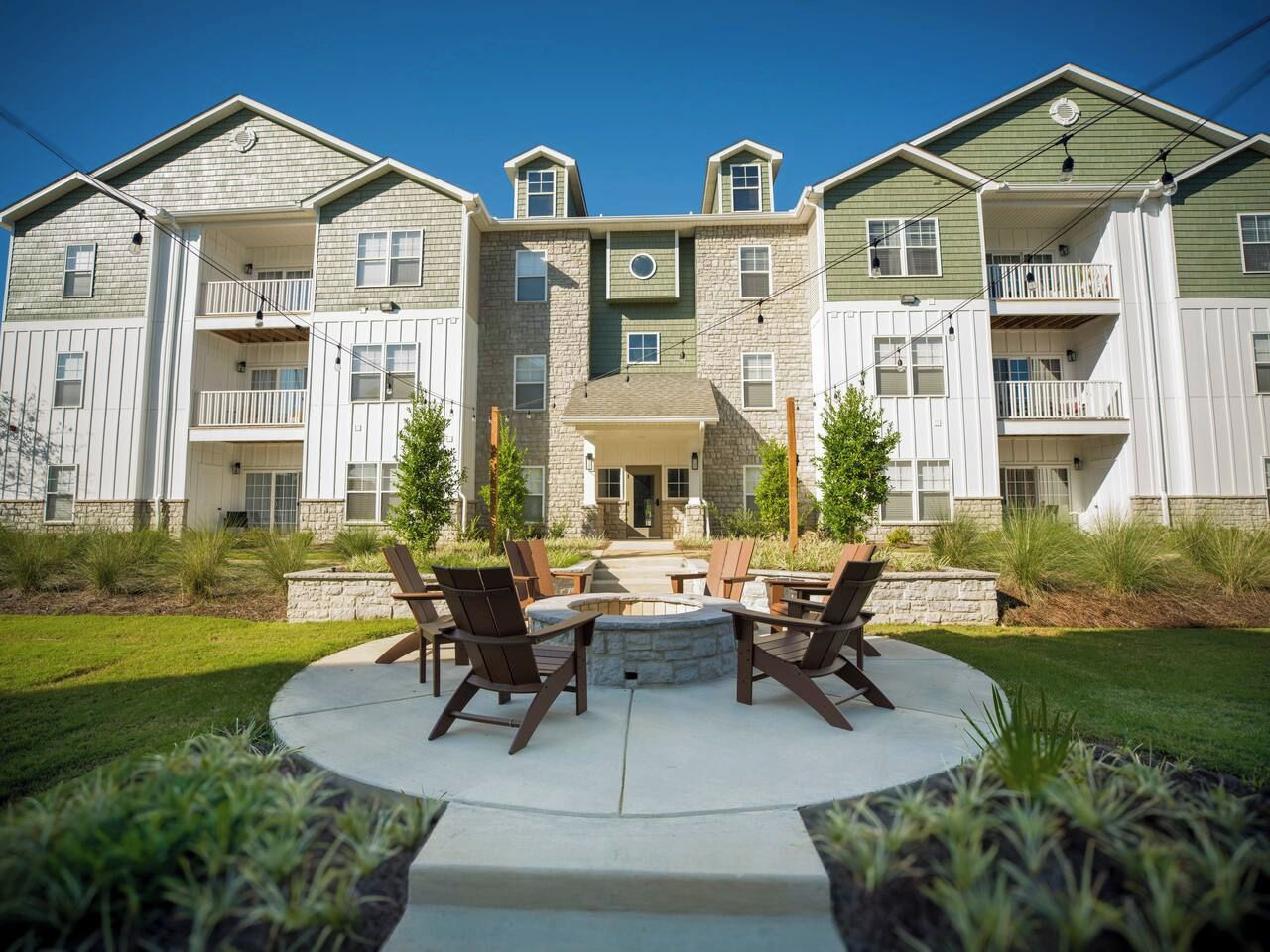 A multi-story building with a central courtyard featuring outdoor seating and a fire pit.