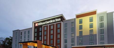 A multi-story hotel with a prominent entrance and a sign reading 'Hilton Garden Inn.'